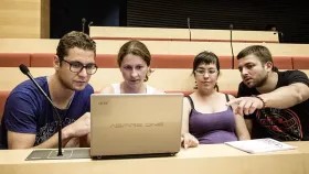 Teachers in classroom pointing at laptop