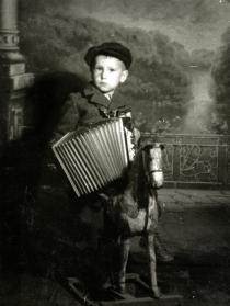 Nisim Navon's cousin Jakov Navon poses with accordion and toy horse
